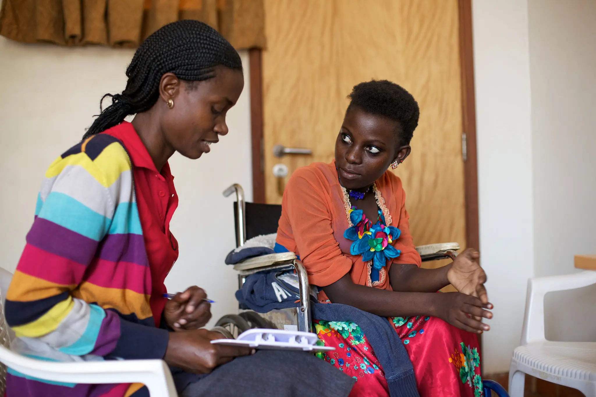 A healthcare worker sits with a patient. Photo provided courtesy of ACS