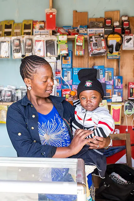A woman holds a toddler in a store. Photo by: Melinda Stanley