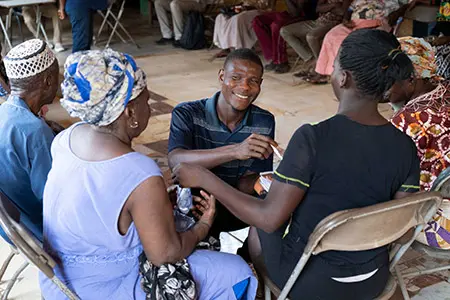 Medium shot of two men and two women sitting close to each other during a community meeting