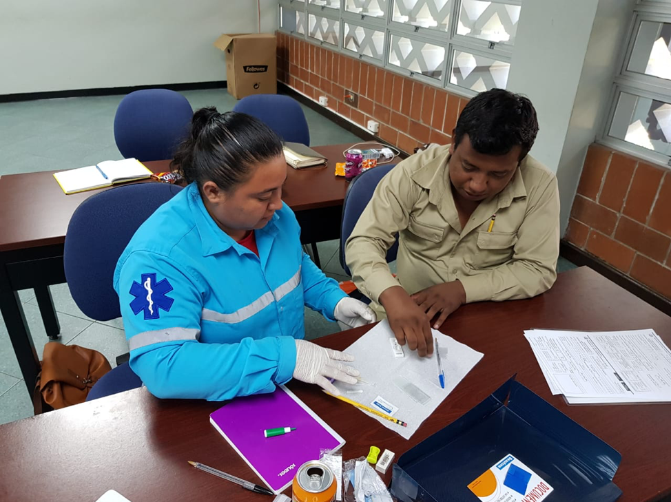 A health worker performs a malaria test on a patient.