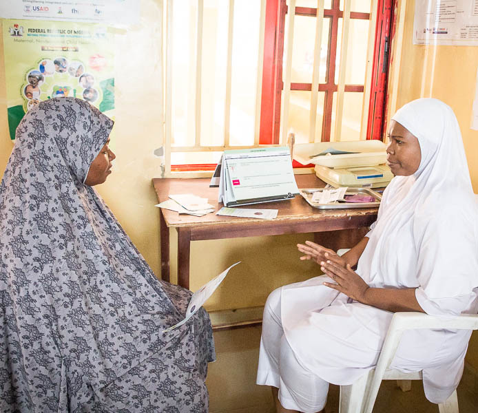 A health worker advises a woman.