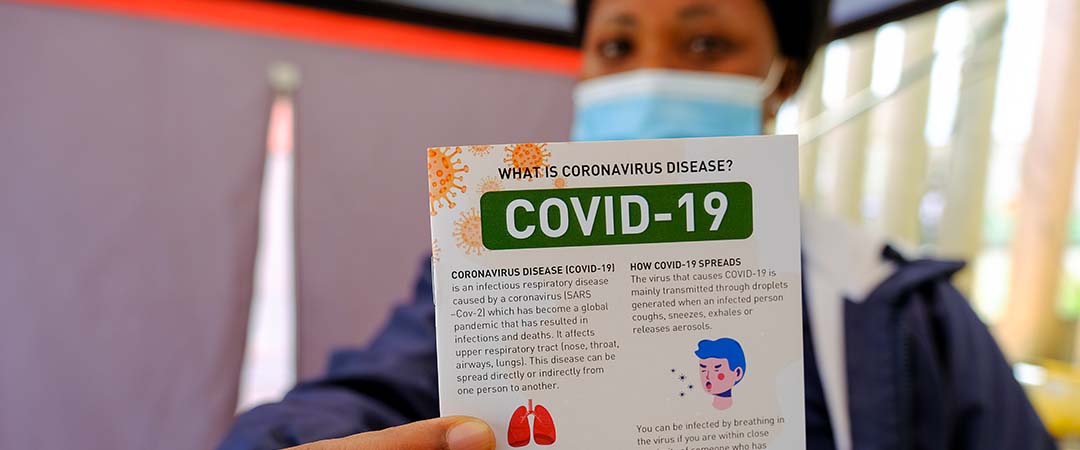 A health workers holds a COVID-19 information pamphlet