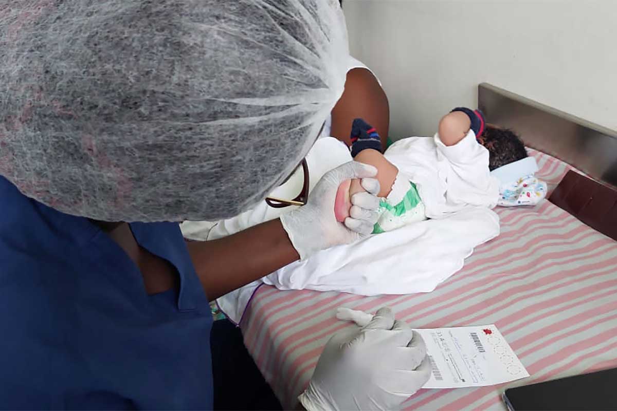 A trained nurse taking sample from a newborn using the heel prick method