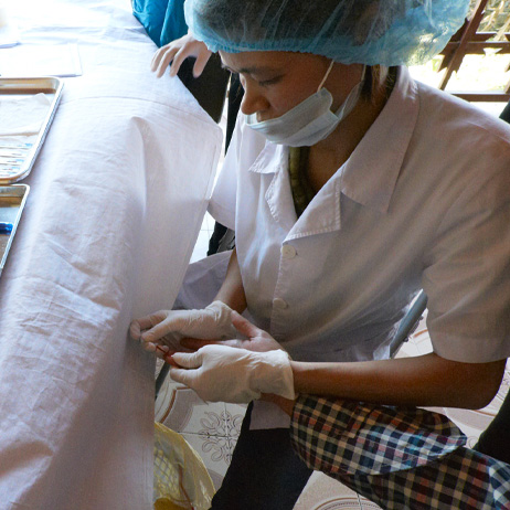 Nurse performing a finger prick test on a patient