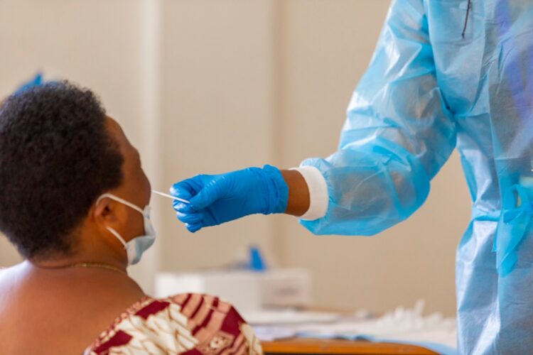 Nurse administers the COVID-19 antigen test to a woman