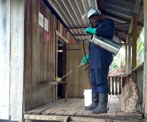 A man sprays mosquito insecticide on the walls of a house in Honduras